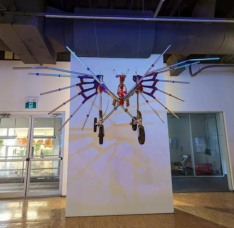 A walker with crutch wings is hanging from the ceiling.